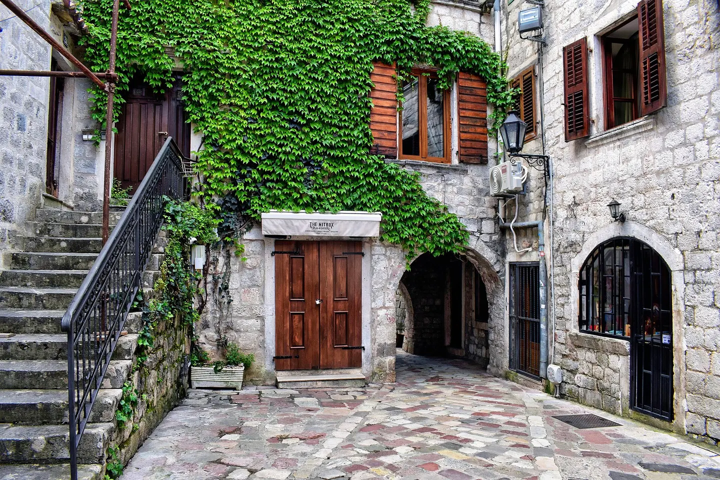 Stone courtyard, steps and shuttered houses in Kotor Old Town