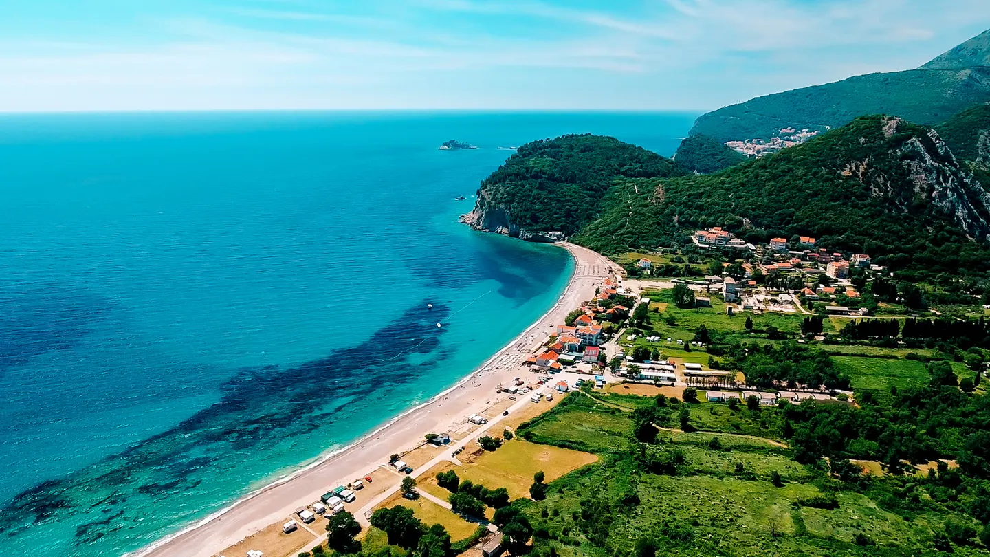 Breiter Strand und grüne Landzunge bei Buljarica